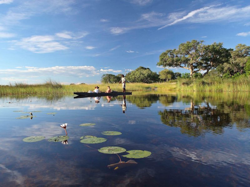 SKT Luxushotels Rundreisen Botswana Xaranna Experience Mokoro ride guests lounging on the
